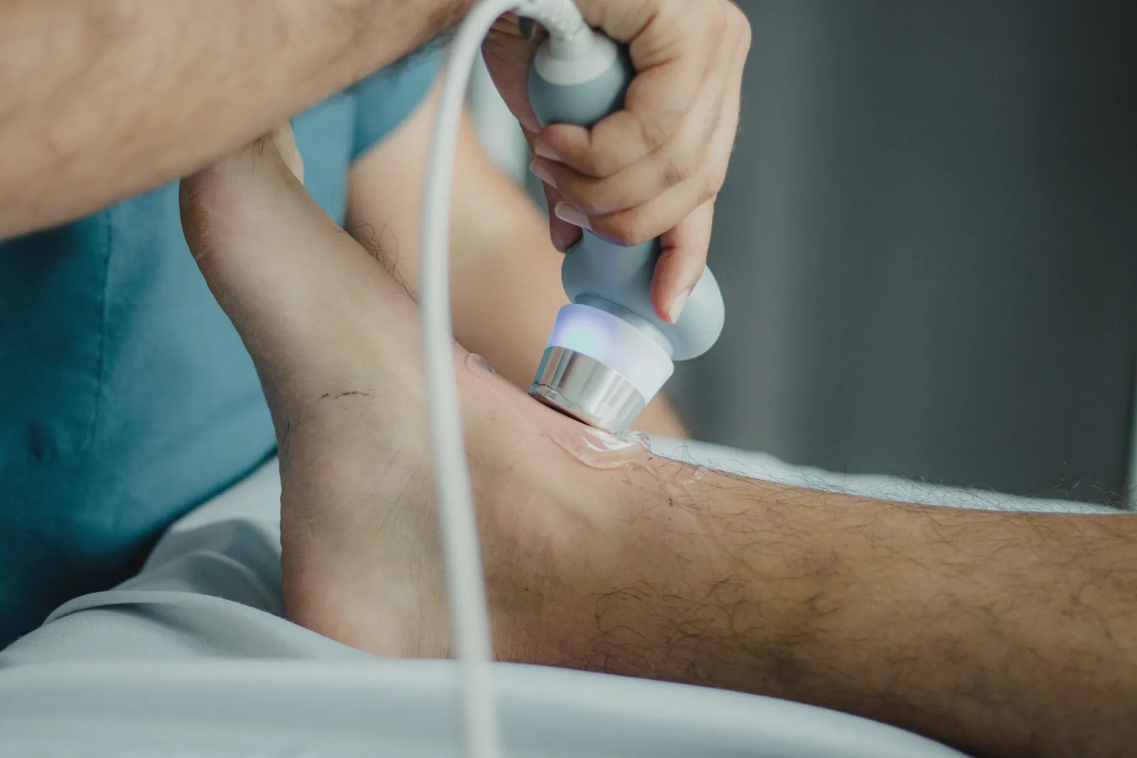 An ultrasound probe passed over a patient’s lower leg.