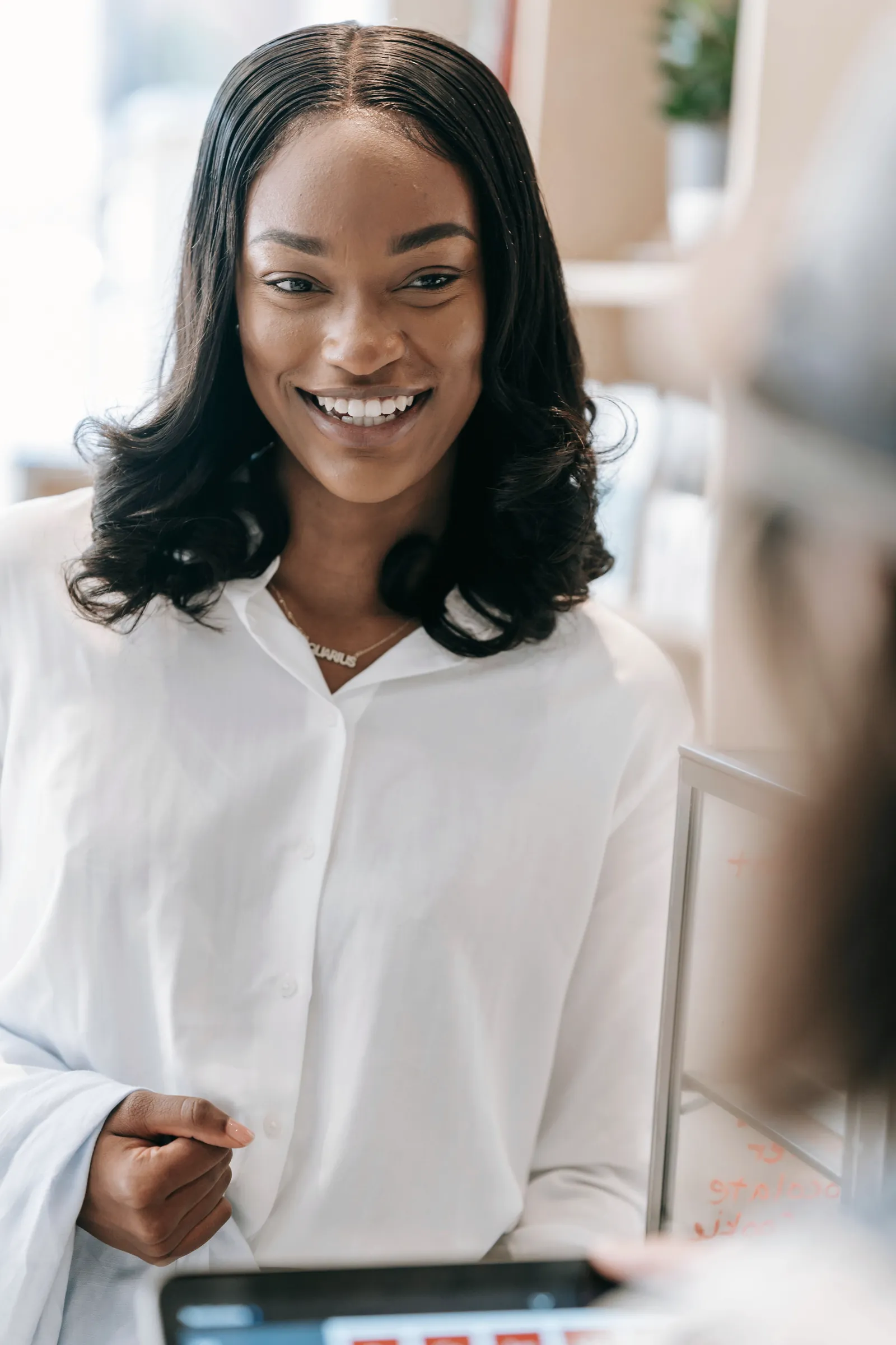 A smiling woman holding a tablet.