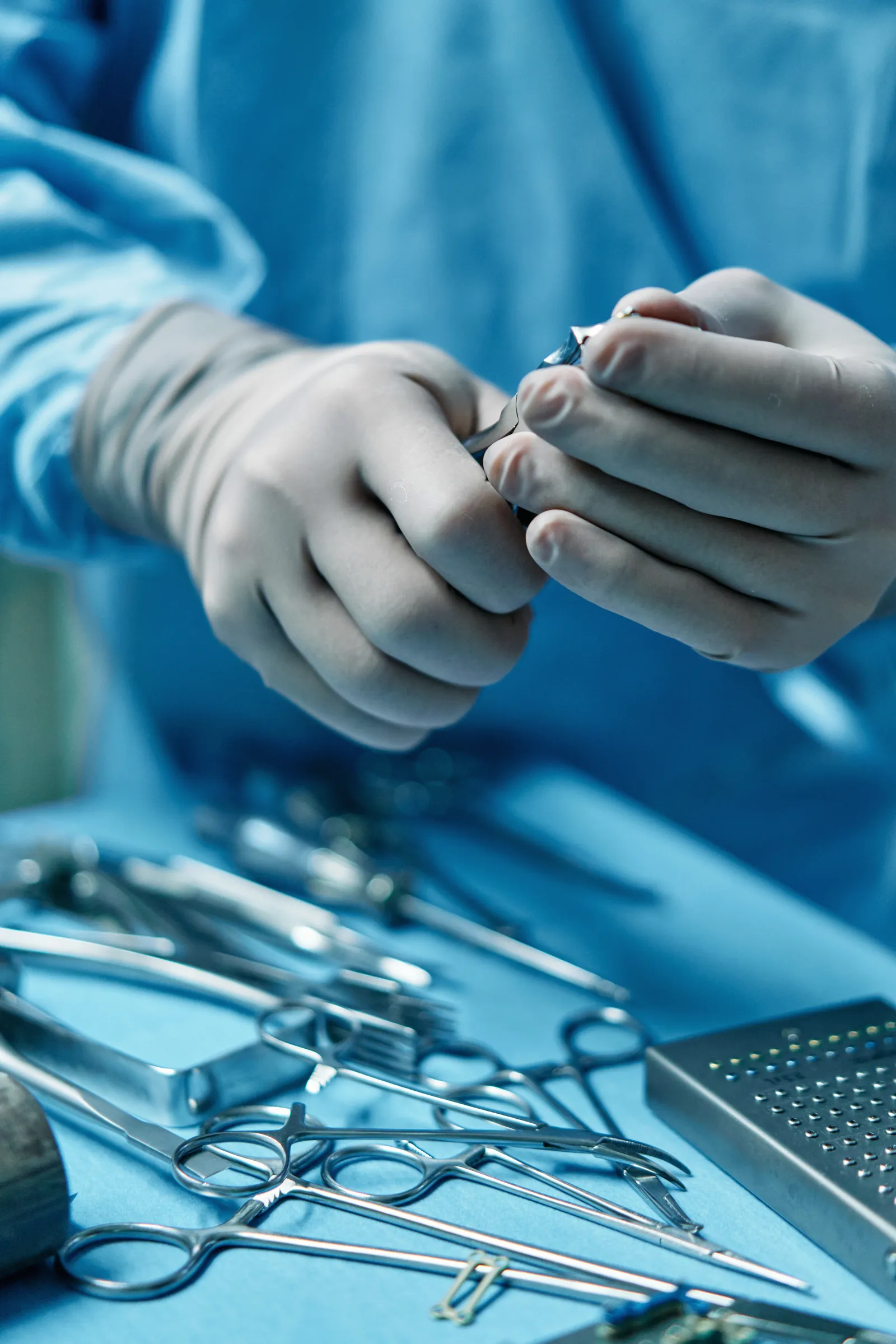 Surgical instruments passed between gloved hands.
